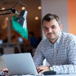 Trabajador sonriente frente al ordenador revisando su derecho al reingreso tras excedencia