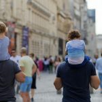 Padres con custodia compartida llevando a sus hijos en los hombros