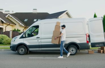 Autónomo descargando cajas de su vehículo de trabajo
