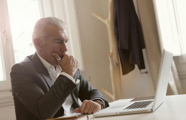 Hombre revisando en su portátil una notificación del SEPE sobre devolución de prestaciones por desempleo